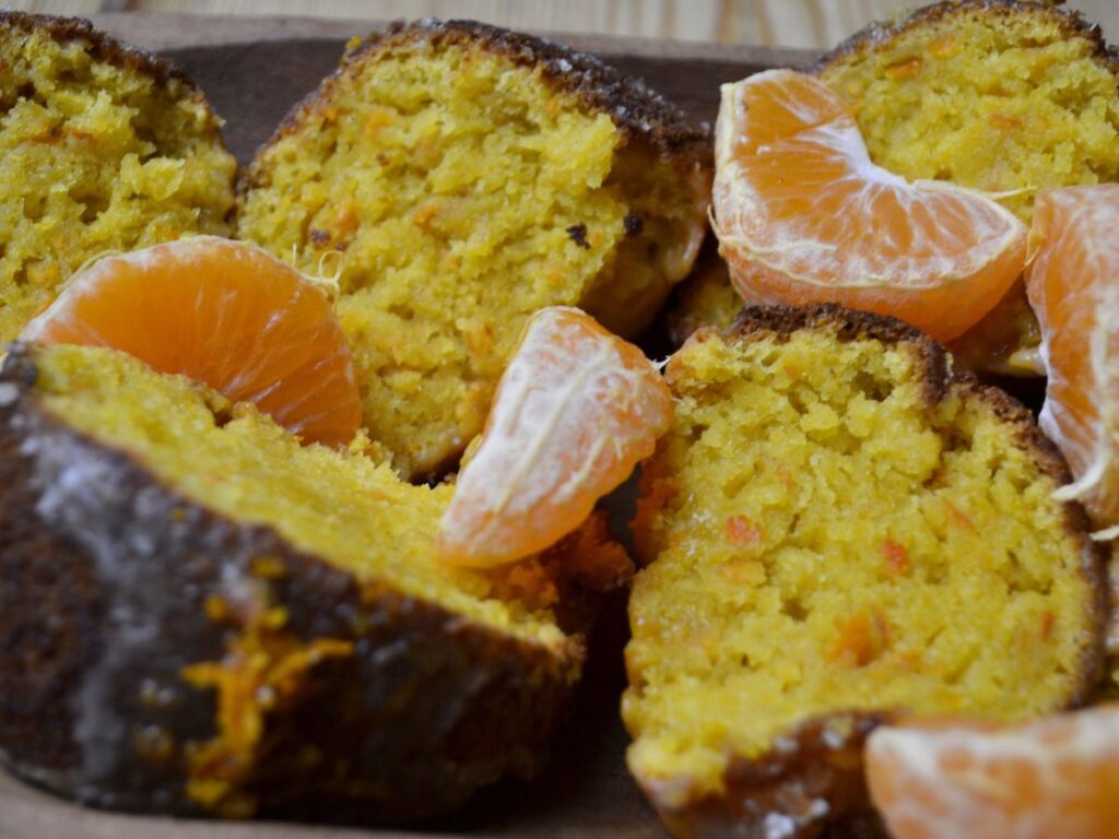 cut pices of a mandarin orange cake with pieces of mandarin orange.