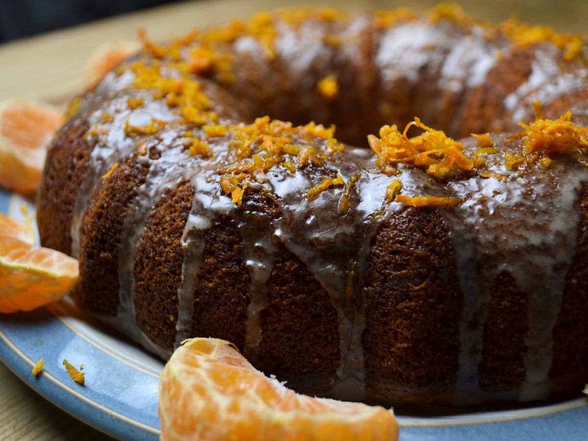 a clementine cake with clementine pieces around it and grated on the top