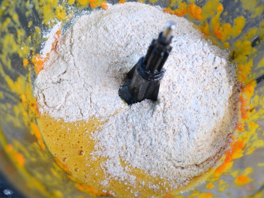 orange mixture with wholemeal flour in a food processor 