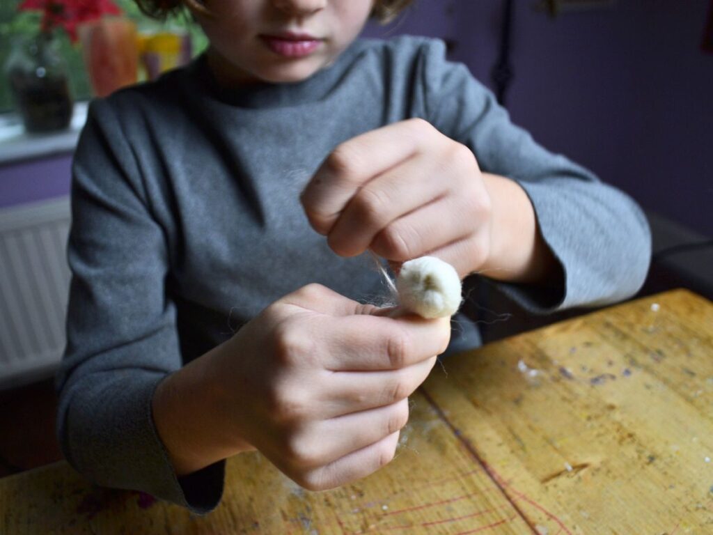 A boy making a wool angel.