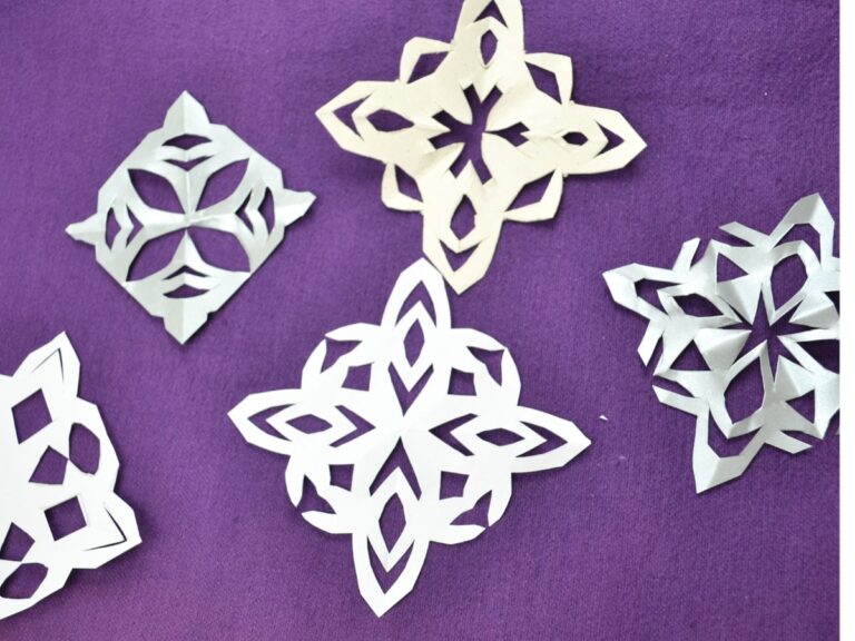5 paper snowflakes on a purple top