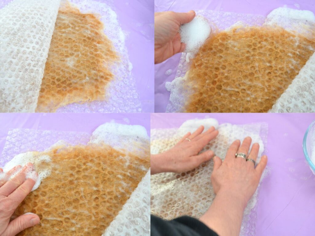 Two bubble wrap pieces with wet carded wool in between.
two hands presing the bubble wrap