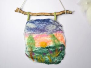A carded wool picture hanging on the wall.