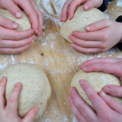 four balls of bread dough each hold by a childs hand