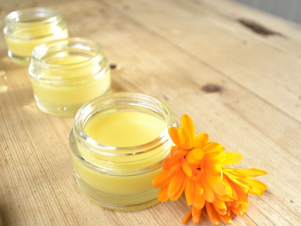 three cosmetic jars with homemade calendula salve