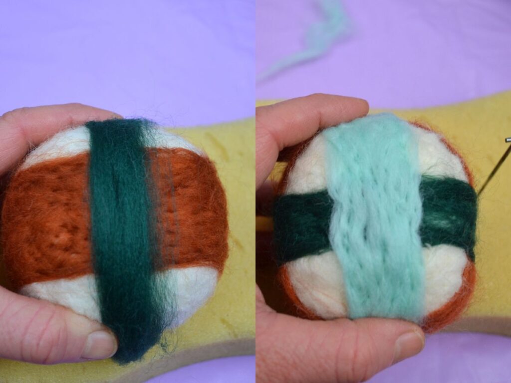 A hand holding a Needle felt ball with coloured wool.