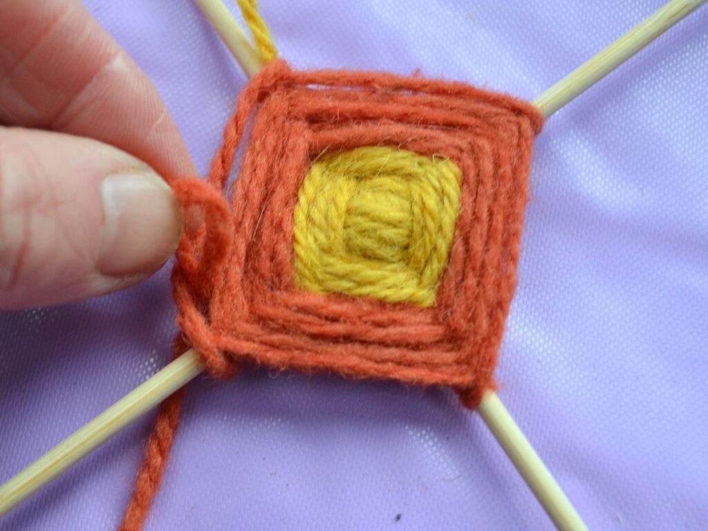 Two colours in a God's eye in the making.