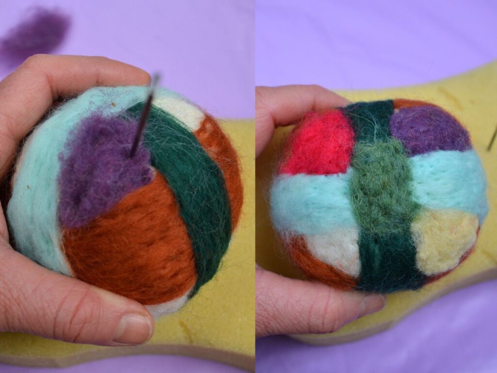 A hand holding a Needle felt ball with coloured wool.