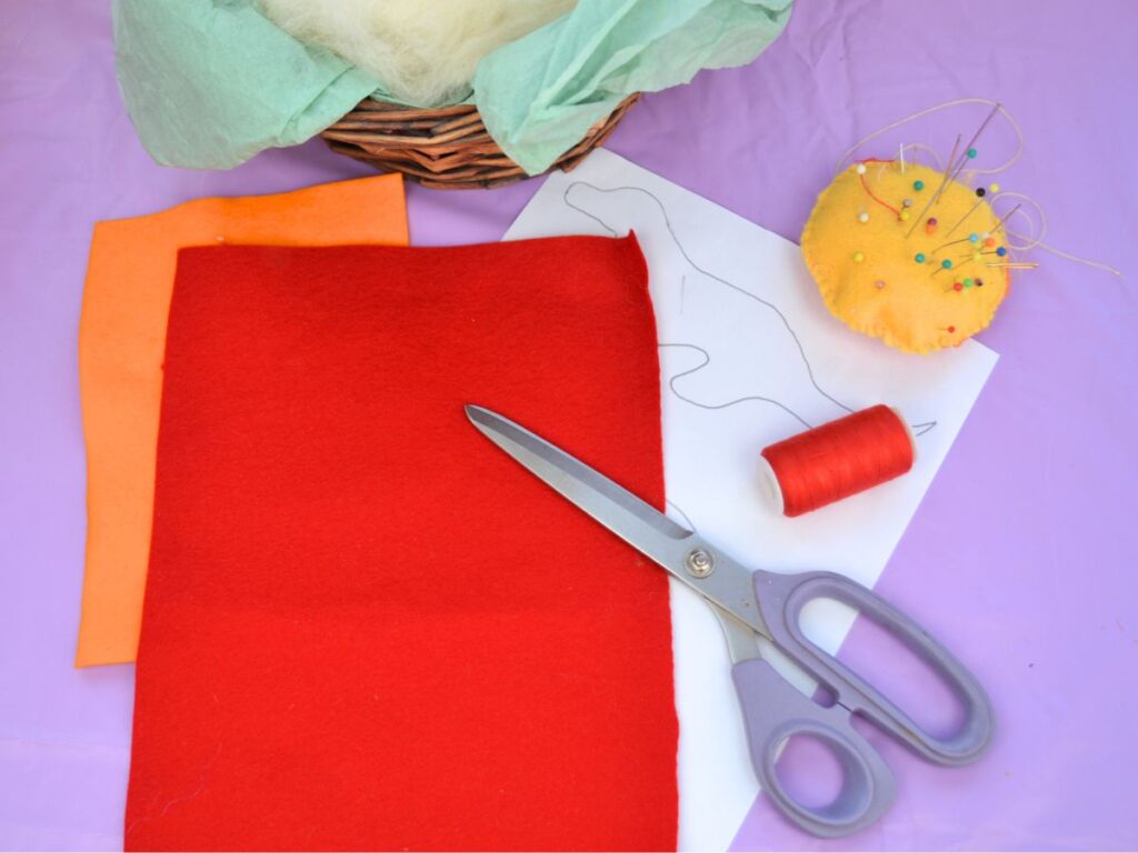 A4-sized pieces of wool felt, scissors, thread and a pin cushion nd a dragon pattern.