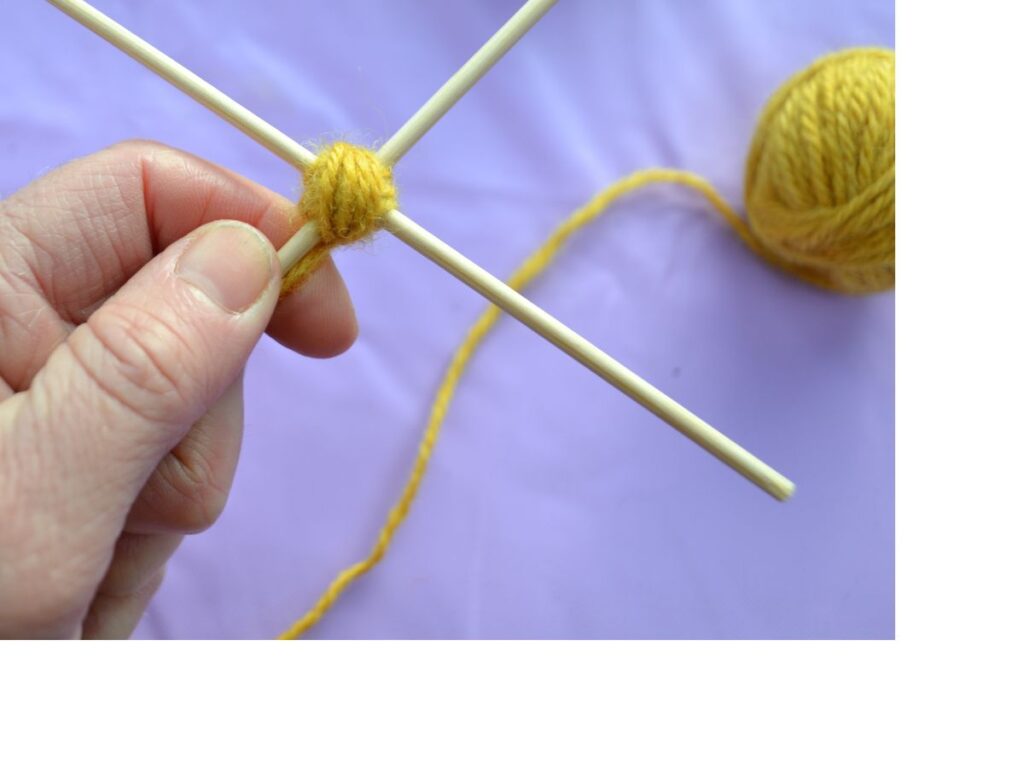 a cross made with sticks with yarn in the middle, the first step of a God's eye.