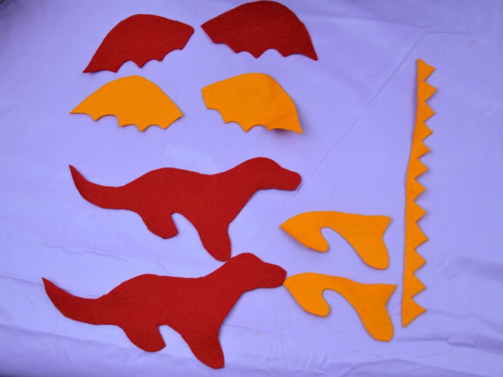 Felt pieces of a dragon, wings, body, legs and spikes.