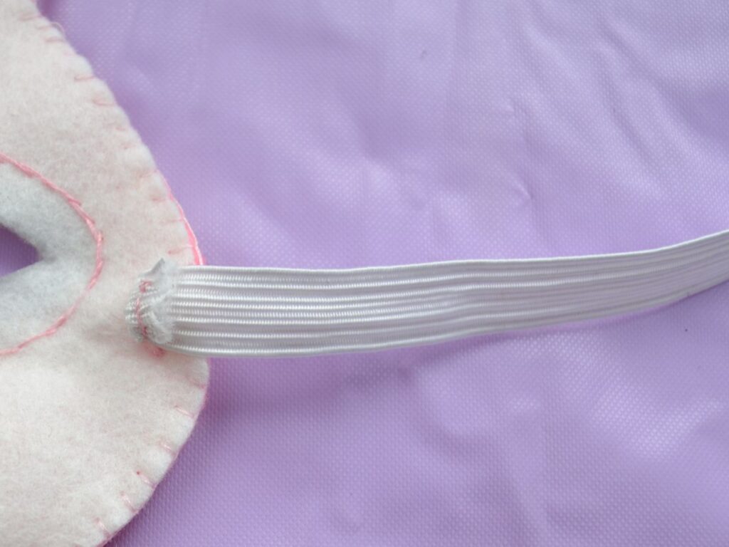 The back of a Felt Bunny mask with a piece of elastic sewn to it.