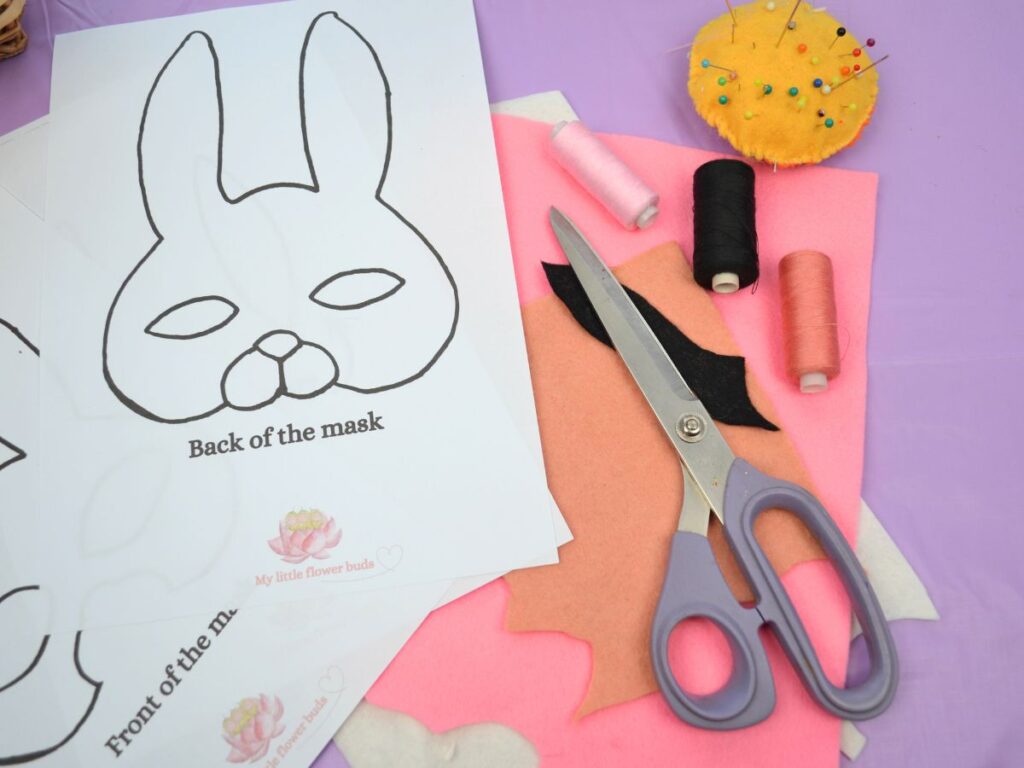 felt, scissors, pins, and the pattern of a felt bunny mask.