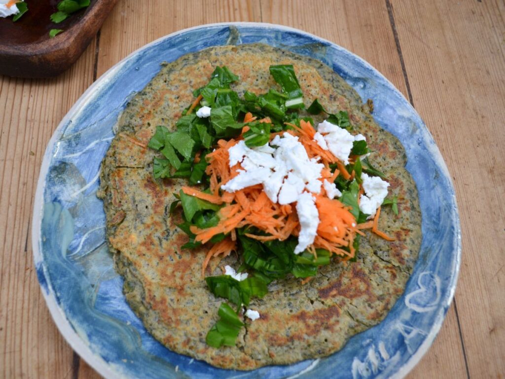 a Nettle Pancake with green salad, carrots and goat's cheese in the middle.