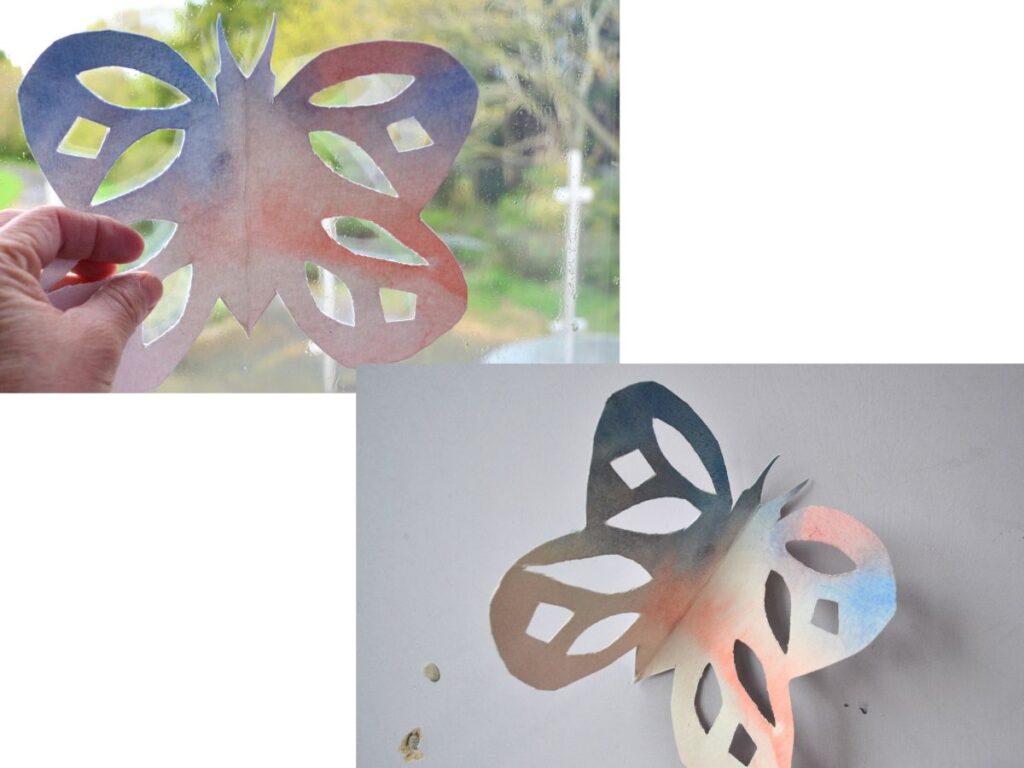 A paper butterfly on the window and on the wall.