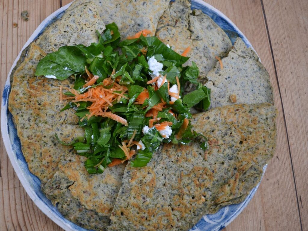 Nettle Pancakes are arranged on a plate with a green salad in the middle.
