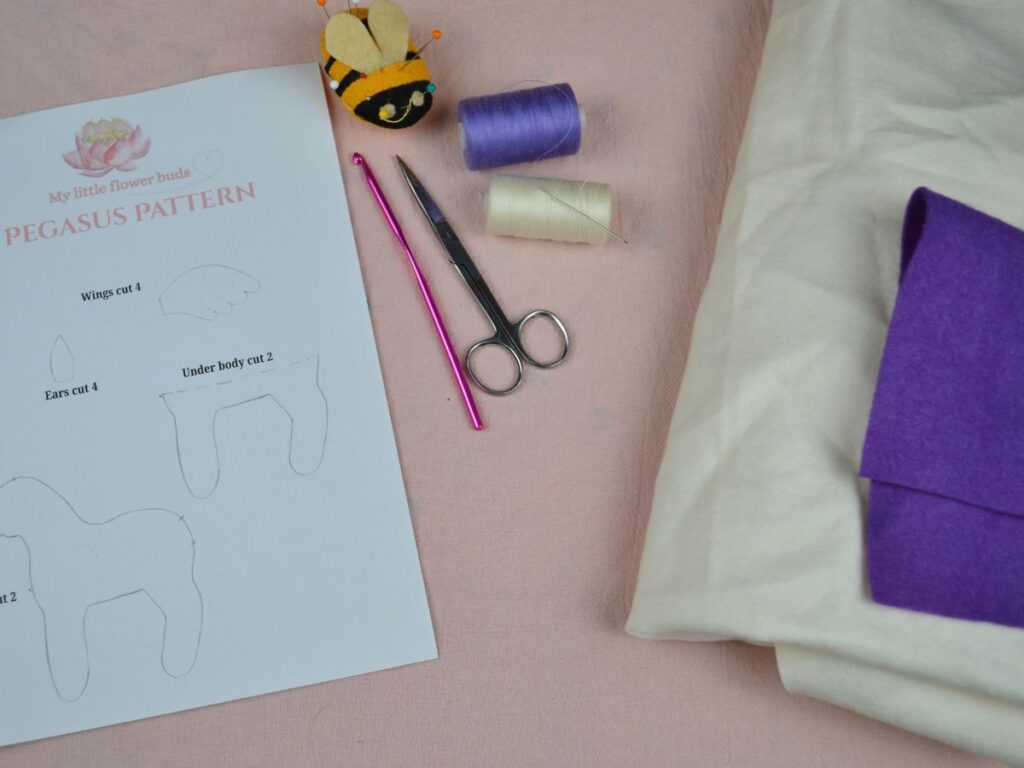 A pegasus pattern, pin and needles, thread, scissors, crochet needle and felt.