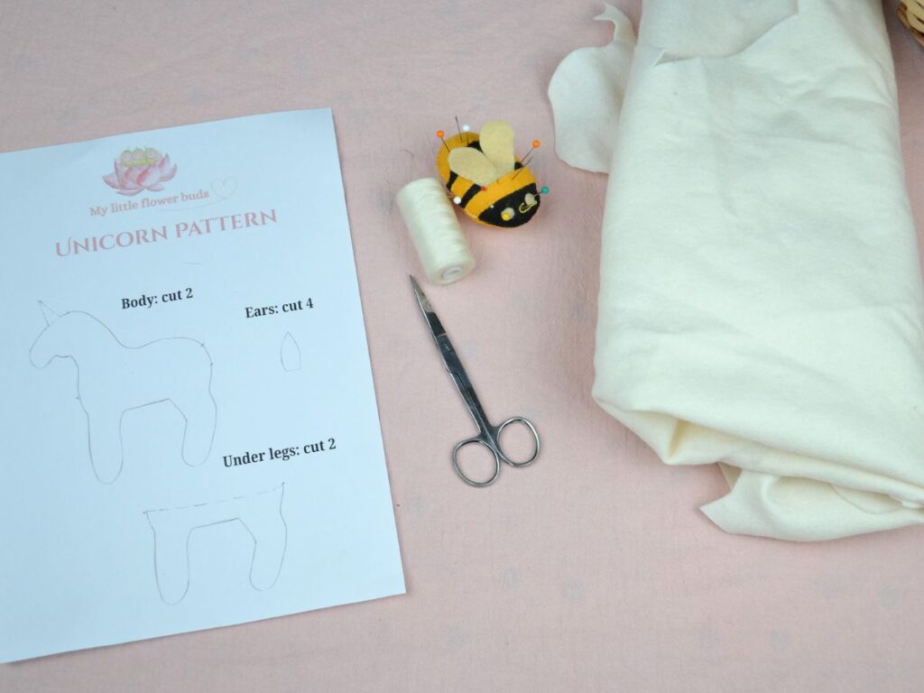 A Felt Unicorn pattern, scissors, needles and thread and felt.