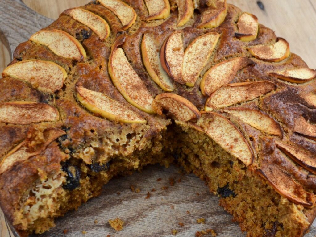 A 3/4 baked Apple Cake in a cake tin.