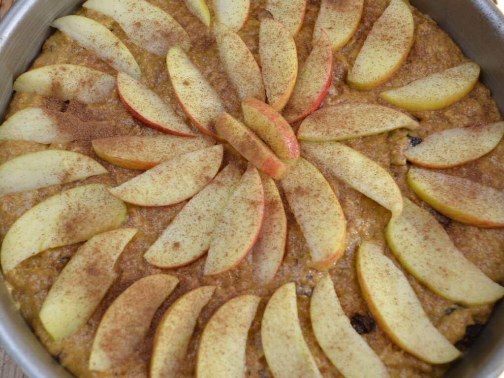 Apple Cake in a tin with apple slices on it.