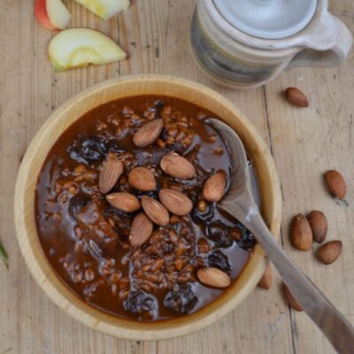 Apple porridge in a wooden plate almonds.