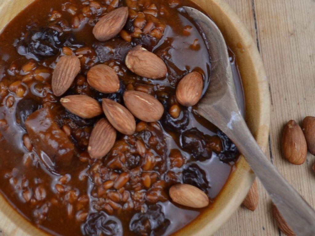 A wooden bowl with Apple porridge and almonds.