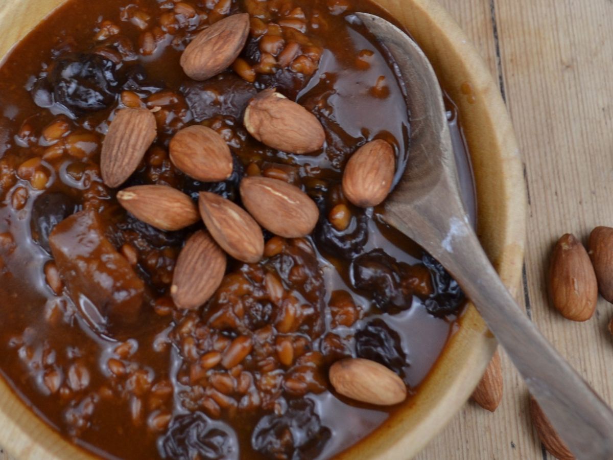 Apple porridge in a wooden bowl with almonds.