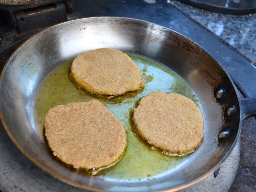 3 Chickpea Schnitzels in a pan with oil.