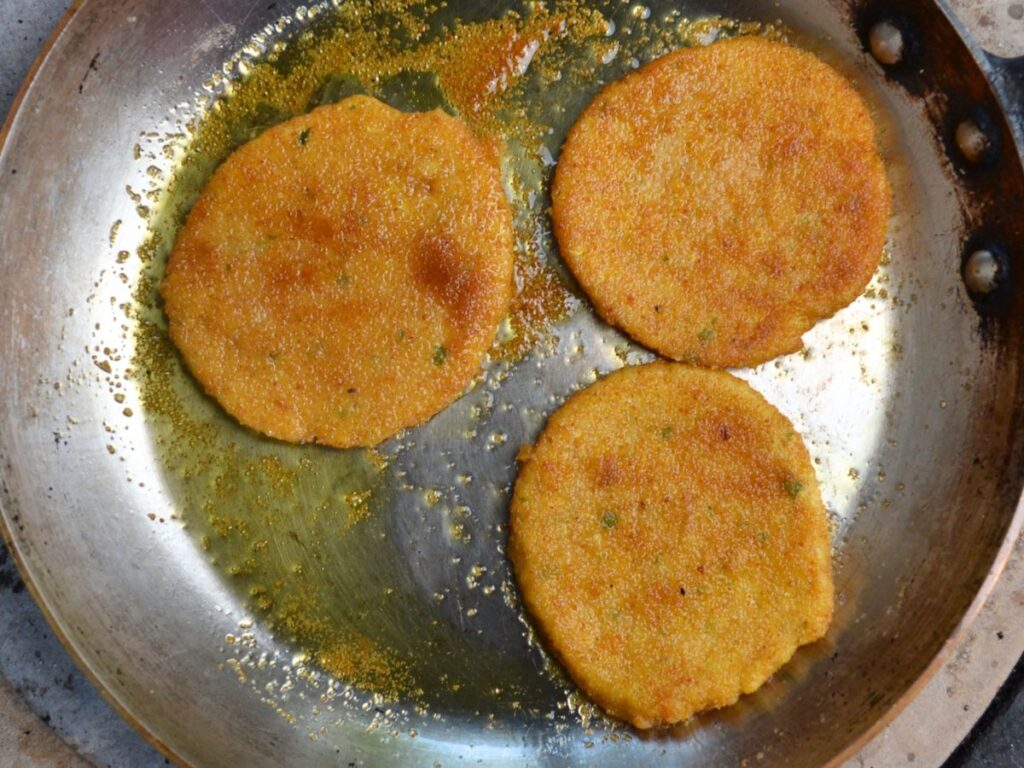 3 Chickpea Schnitzels in a pan with oil.