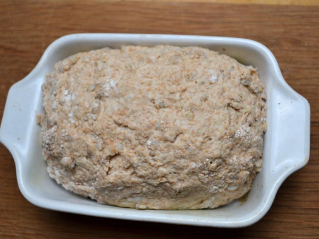 A rice bread dough in a ceramic bread tin