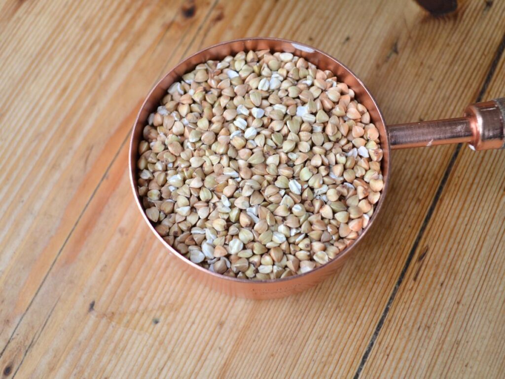 Buckwheat grain in a measuring cup.
