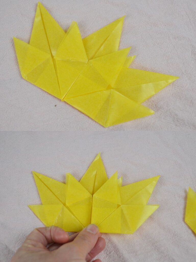 A hand holds an Autumn paper leaf.
