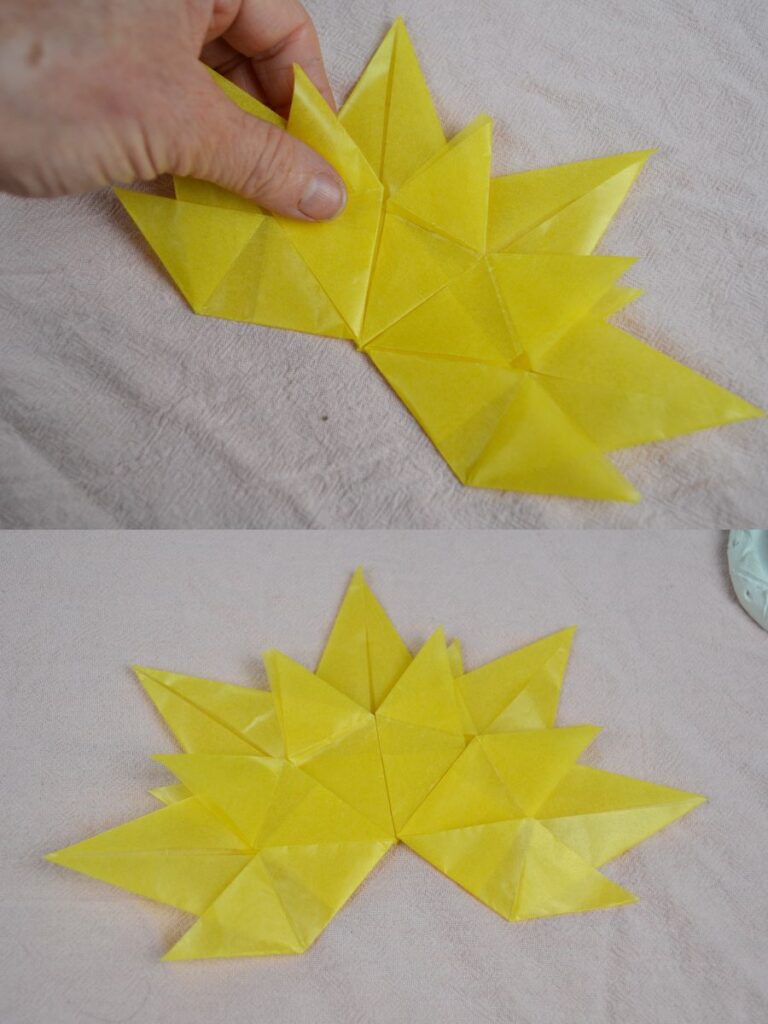 A hand holds an Autumn paper leaf.