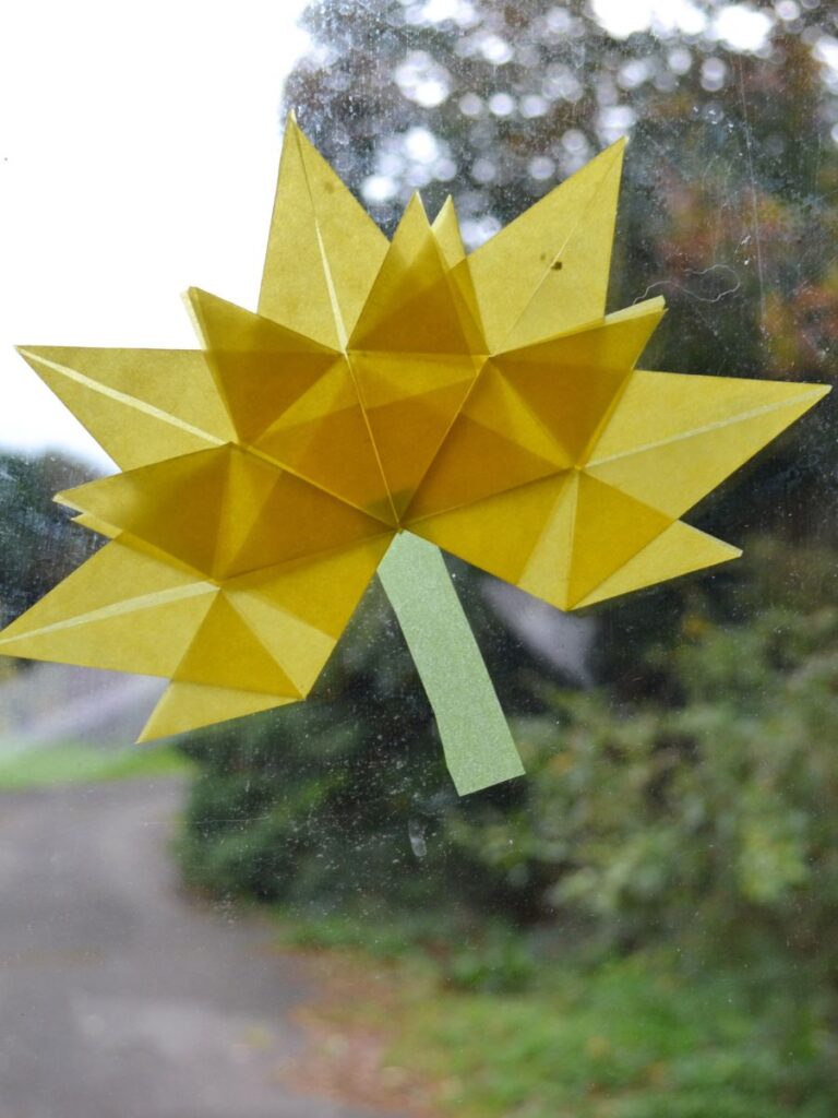An autumn paper leaf on a window.