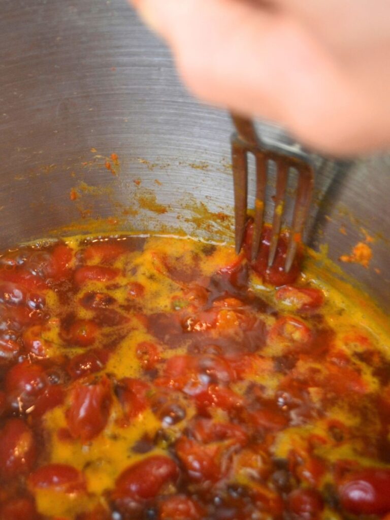 A fork pressing a rosehip to the inside side of a pot.